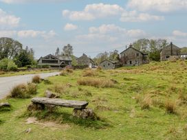 An outdoor area with stone houses and a bench at Woodloft Cottage Elterwater near Chapel Stile