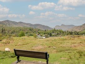 A view of a village with mountains in the background at Woodloft Cottage Elterwater near Chapel Stile