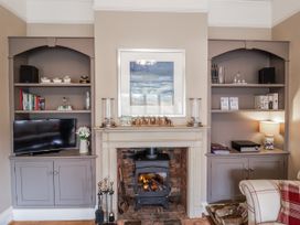 A living room with a television and fireplace at Holly Lodge in Aldeburgh