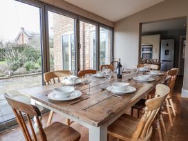 A dining room with a wooden table and chairs at Holly Lodge in Aldeburgh