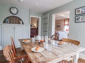 A dining room with a wooden table and chairs at Holly Lodge in Aldeburgh
