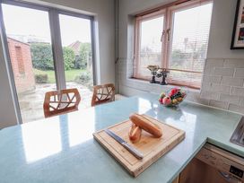 A kitchen with a cutting board and fruit bowl at Holly Lodge in Aldeburgh