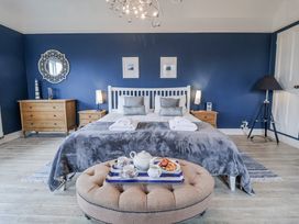 A bedroom with a bed, dresser, and tea set at Holly Lodge in Aldeburgh