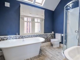 A bathroom with a bathtub and toilet at Holly Lodge in Aldeburgh