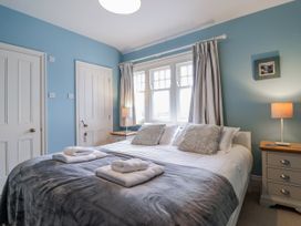 A bedroom with a bed and bedside table at Holly Lodge in Aldeburgh
