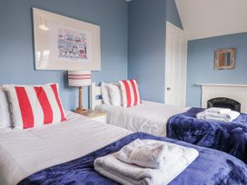 A bedroom with two beds and wall art at Holly Lodge in Aldeburgh