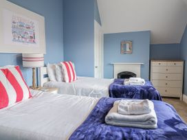 A bedroom with two beds and a dresser at Holly Lodge in Aldeburgh