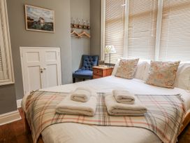 A bedroom with a bed and towels on top at Holly Lodge in Aldeburgh