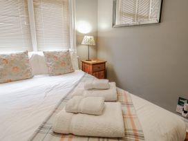 A bedroom with a bed and towels on it at Holly Lodge in Aldeburgh