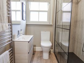 A bathroom with a shower, sink, and toilet at Holly Lodge in Aldeburgh