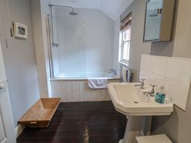 A bathroom with a shower, bath, sink, and window at Lavender House, Aldeburgh