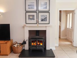 A living room with a fireplace and pictures on the wall at Seadrift Dunwich Near Westleton