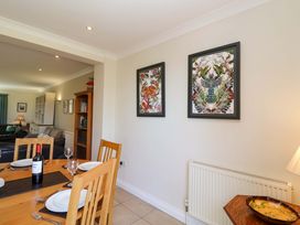 A dining room with a wooden table and wall art at Seadrift Dunwich Near Westleton