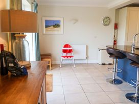 A kitchen with a high chair and bar stools at Seadrift Dunwich Near Westleton