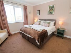 A bedroom with a bed and bedside table at Seadrift in Dunwich Near Westleton