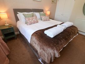 A bedroom with a bed and bedside lamp at Seadrift in Dunwich Near Westleton
