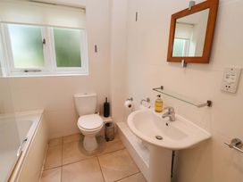 A bathroom with a bathtub, sink, toilet, and window at Seadrift in Dunwich Near Westleton