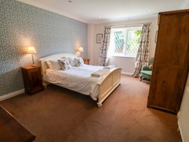 A bedroom with a bed and nightstand at Seadrift in Dunwich Near Westleton