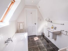 A bathroom with a bathtub and sink at Seadrift in Dunwich Near Westleton