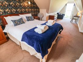 A bedroom with a bed and a fan at Seadrift in Dunwich Near Westleton