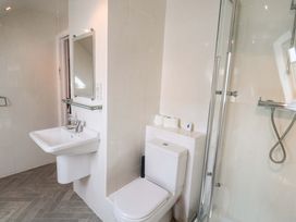 A bathroom with a sink, toilet, and shower at Seadrift in Dunwich Near Westleton