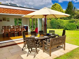 An outdoor dining setup with table and chairs in a garden at Rippleway, Walberswick