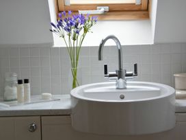 A bathroom with a sink and flowers at Rippleway, Walberswick
