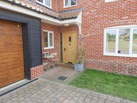 An outdoor entrance with a door, table, chairs, and garage at Meadowsweet, Blythburgh