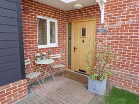 An entrance with a wooden door and a small table and chairs at Meadowsweet House Blythburgh near Reydon