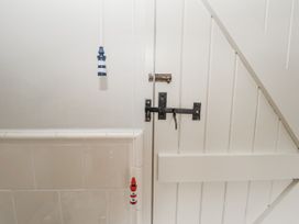 A door with a bolt and decorations in a bathroom at Mariners Cottage, King Street, Aldeburgh