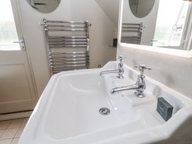 A bathroom with a double sink and mirror at Mariners Cottage, King Street, Aldeburgh