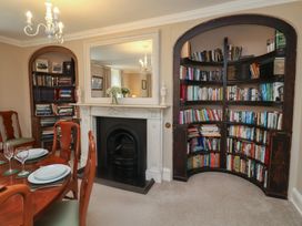 A dining room with a table and bookshelf at Henstead Hall Henstead near Beccles