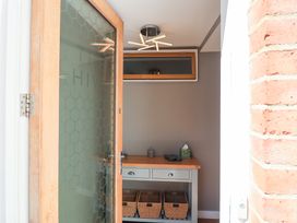 An entryway with a table and baskets at The Hive, Southwold