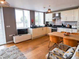 A kitchen with a dining table and orange chairs at The Hive, Southwold
