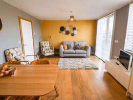 A living room with seating and a table at The Hive, Southwold