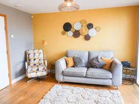 A living room with a sofa and armchair at The Hive in Southwold