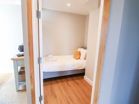 A bedroom with a bed and table at The Hive, Southwold