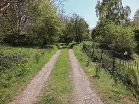 A pathway lined with grass and trees at The Cart House Sudbourne Near Orford