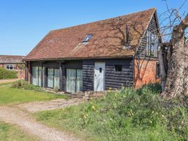 A house with a sloped roof and windows at The Cart House in Sudbourne Near Orford