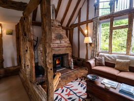 A living room with a fireplace and sofa at Wassicks Cottage, Haughley