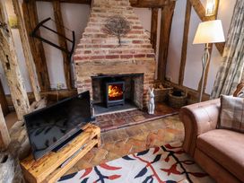 A living room with a fireplace and television at Wassicks Cottage, Haughley
