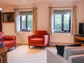 A living room with chairs and a television at Pine Cottage in Woodbridge