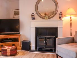 A living room with a sofa and television at Pine Cottage in Woodbridge