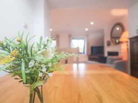 A living room with a table and flowers at Pine Cottage in Woodbridge