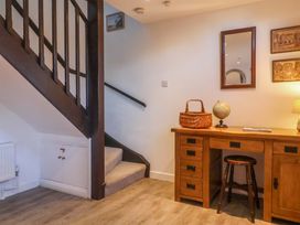A hallway with a desk and stairs at Pine Cottage in Woodbridge