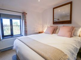A bedroom with a bed and window at Pine Cottage in Woodbridge