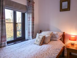 A bedroom with a bed and window at Pine Cottage in Woodbridge