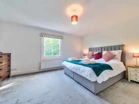 A bedroom with a double bed with pillows and towels beside a window and wooden furniture at Bedingfield House nr Debenham in Debenham 