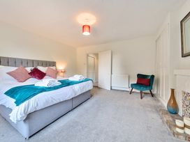 A bedroom with a bed, pillows, towels, a chair, and a vase at Bedingfield House, nr Debenham in Debenham