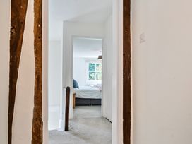 A hallway leading to a bedroom with a bed and window at Bedingfield House nr Debenham